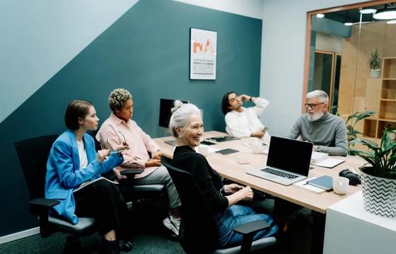 A diverse group of professionals discussing company culture in a modern meeting room, fostering collaboration and engagement.