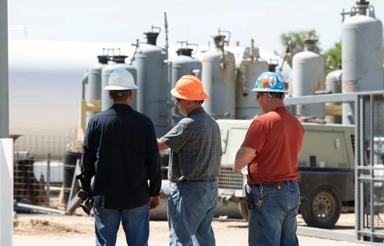 frontline workers, male, looking observing the construction site.