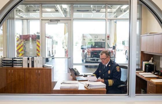 Fire chief reviewing AI software procurement documents at a fire station