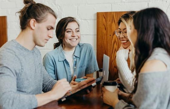 A diverse team working around a computer screen displaying data visuals or AI analytics, symbolizing actionable insights.