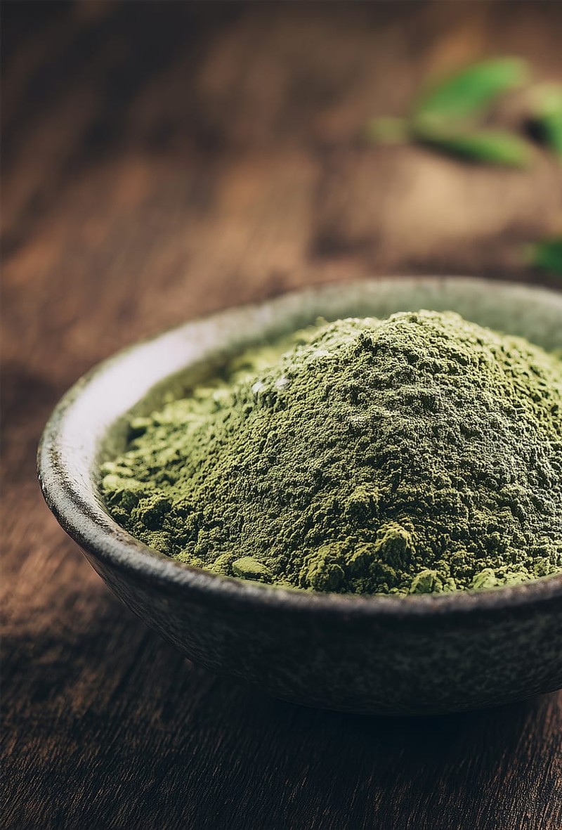 Two bowls of green matcha-style L-Theanine powder with tea leaves