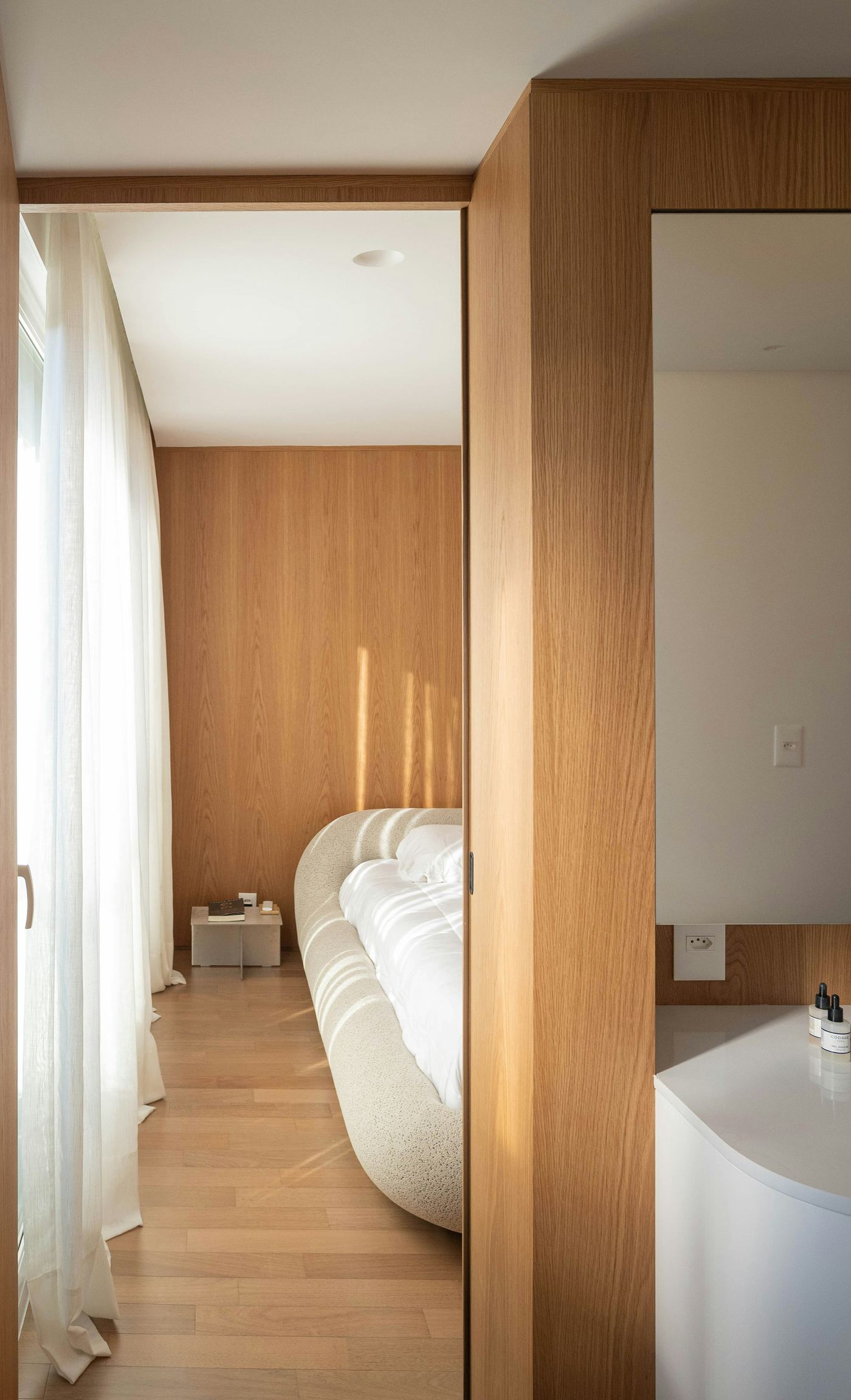 Warm wooden doorway leading into a minimalist interior