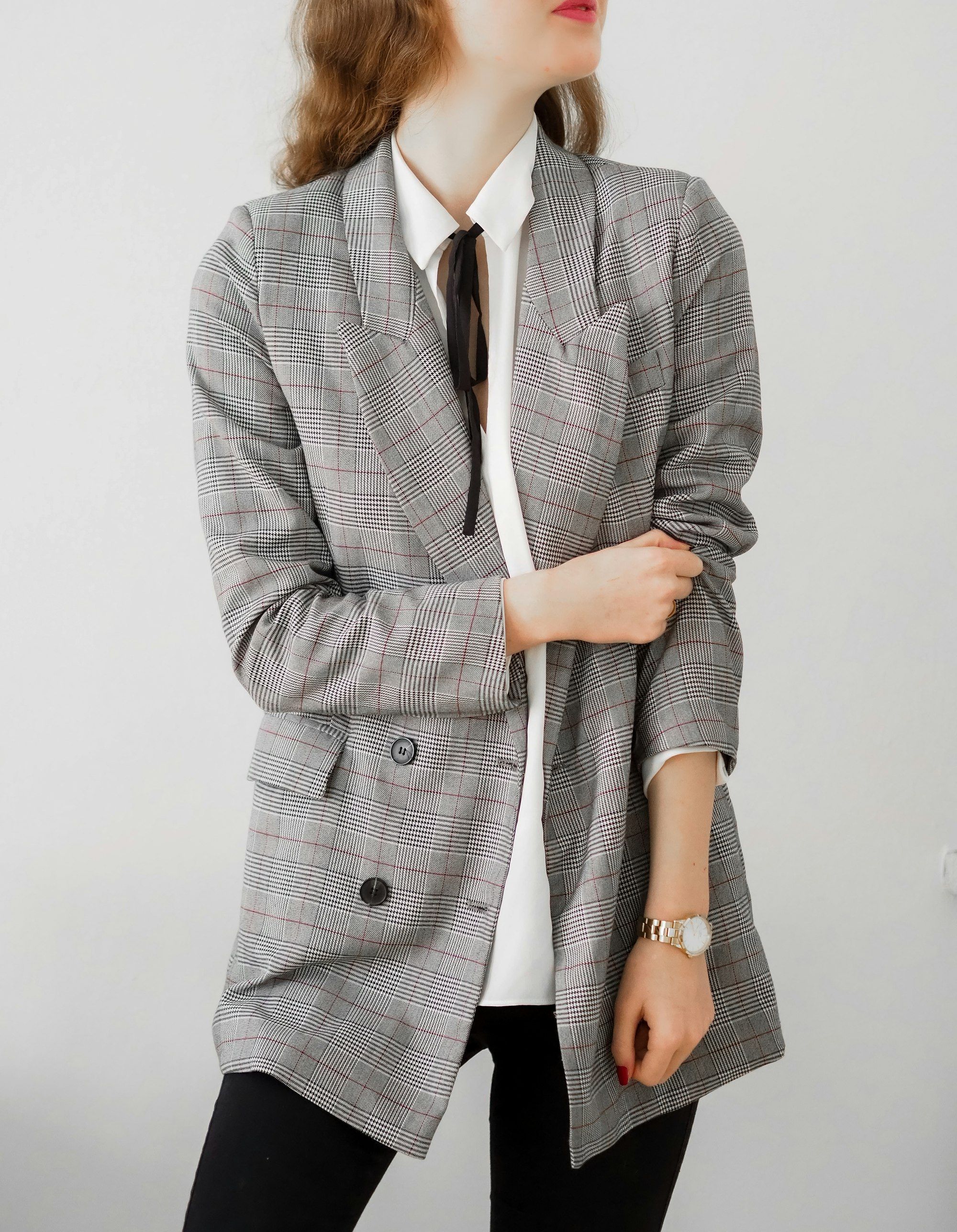 Woman in a grey checked blazer and black trousers