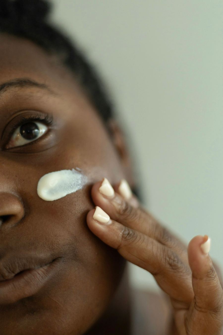 Woman applying moisturiser to her face as part of a winter skincare routine for dry skin