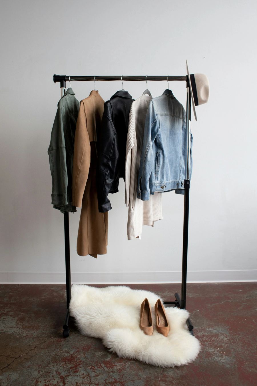 Winter coats and jackets hanging on a clothes rack, the base of a winter capsule wardrobe