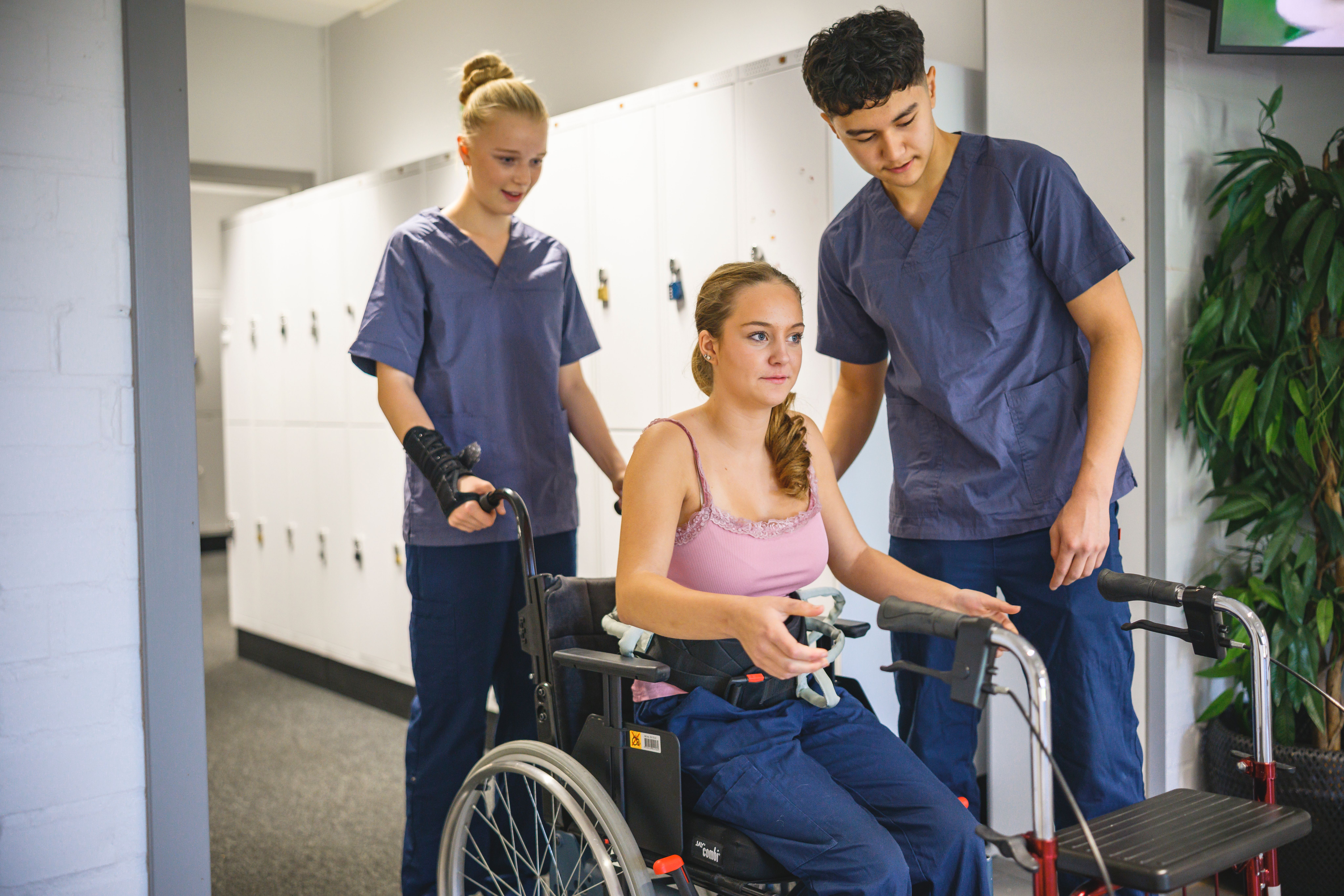 vård och omsorgselev med en annan elev i rullstol