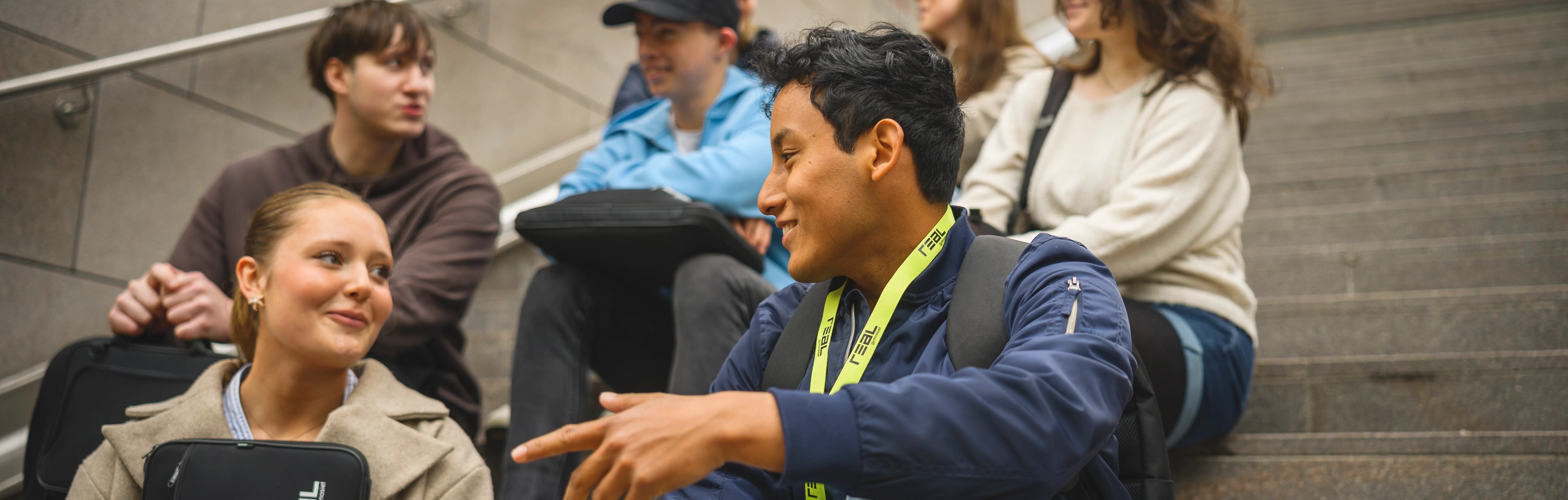 Elever sitter på en trappa