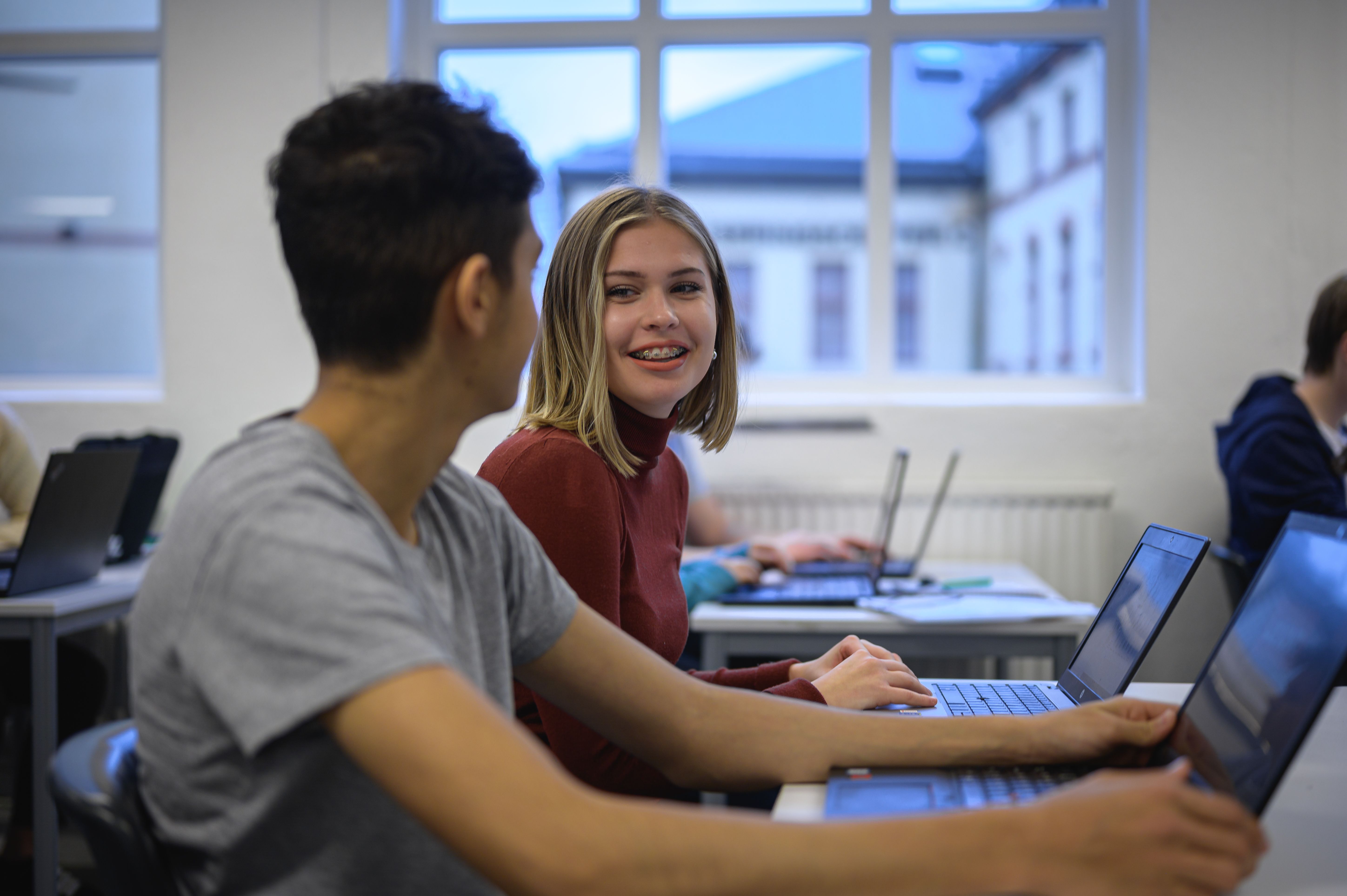 Tjej med tandställning pratar med klasskompis