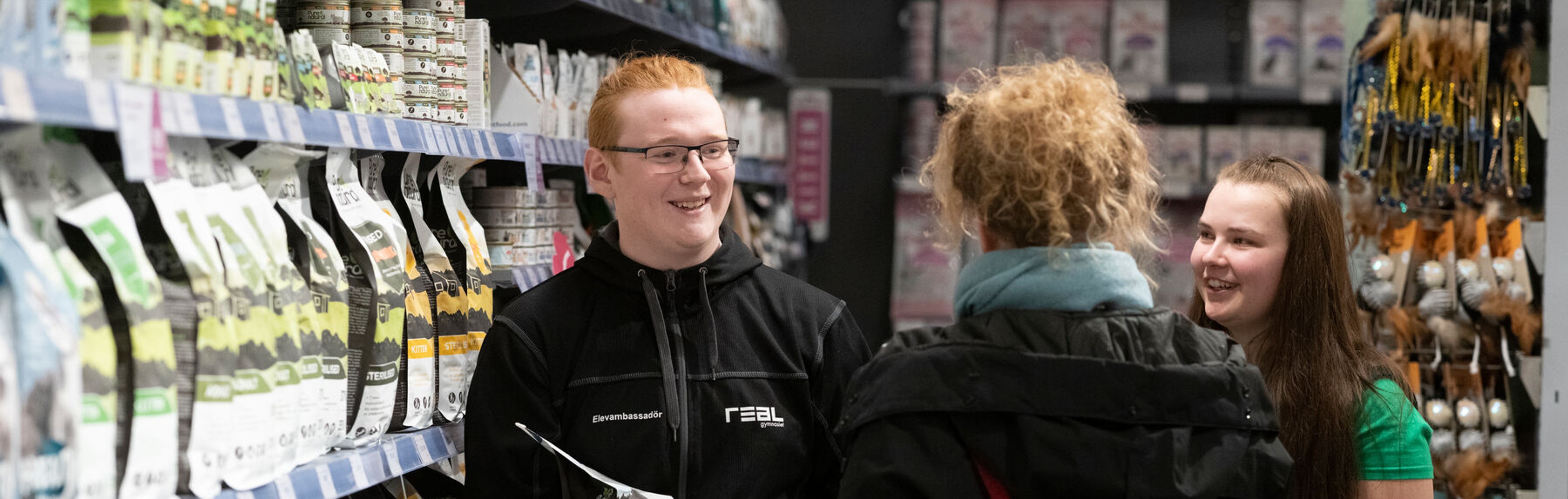 Elev på APL som hjälper en kund välja hundfoder
