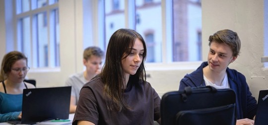 Elev som ler mot kameran