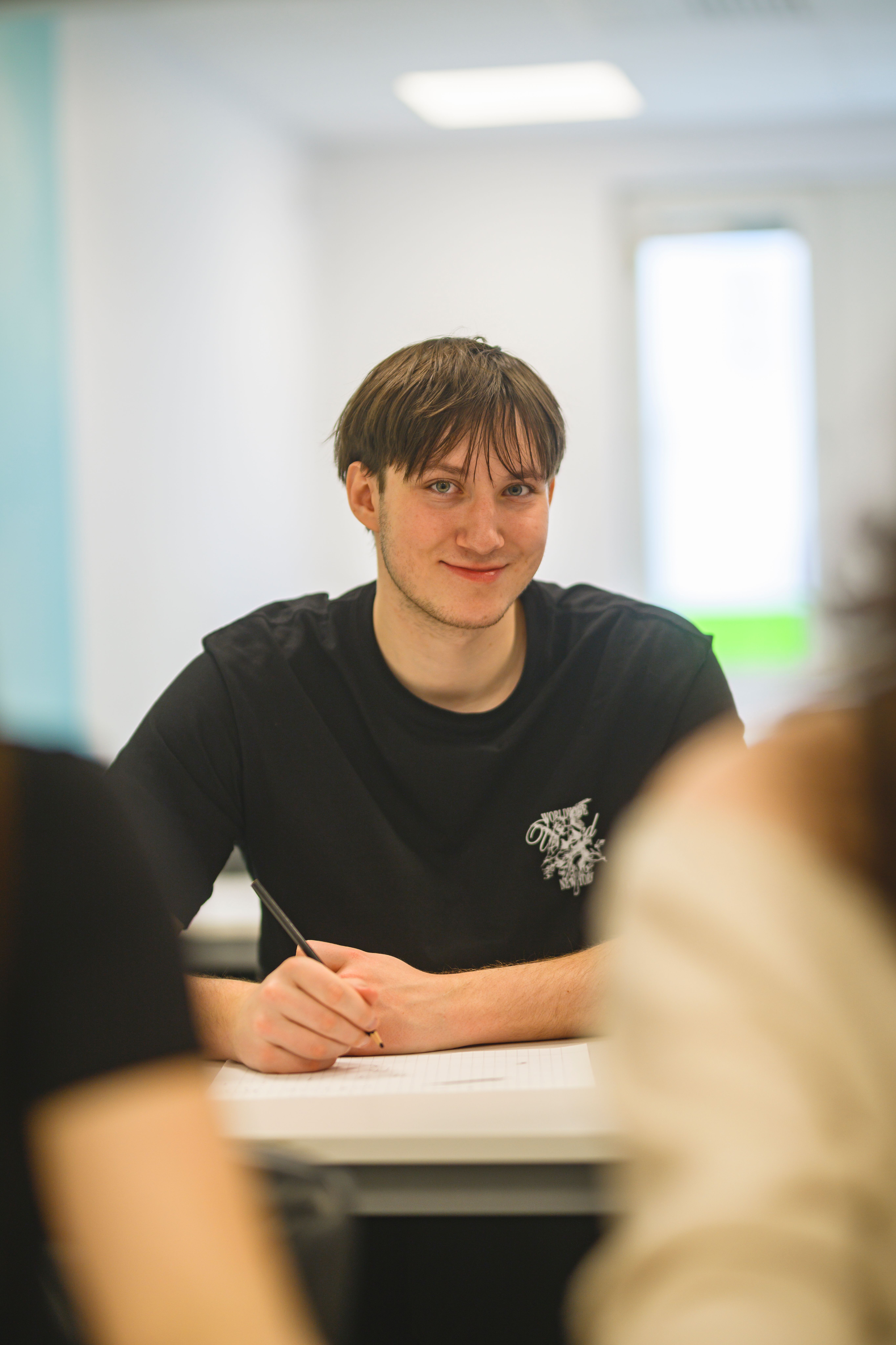 Elev sittande vid bord i klassrum