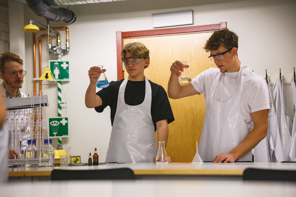 Två elever tittar på provrör i 