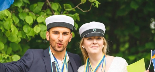 Kille och tjej i studentmössor