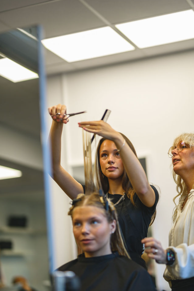 Lärare hjälper elev med klippning