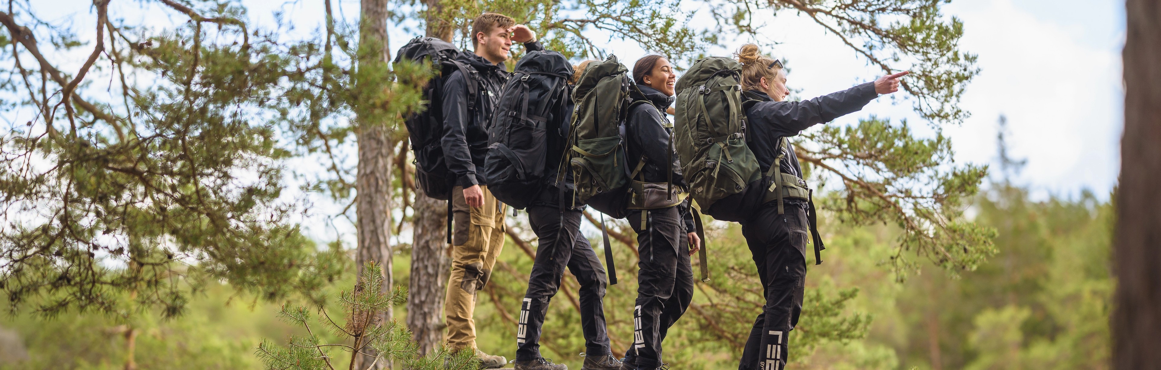 Gymnasieelever på vandring i skog