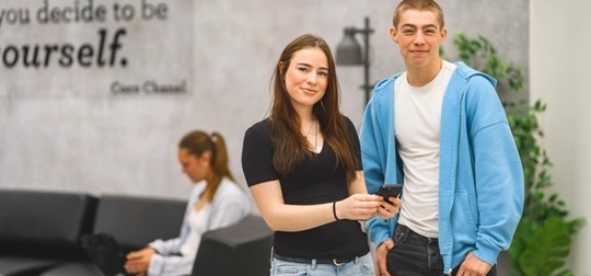 Två elever står inomhus