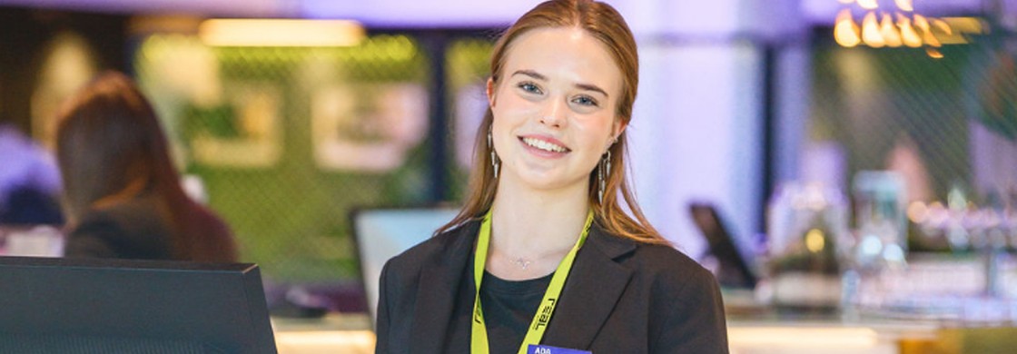 Glad elev som står i receptionen