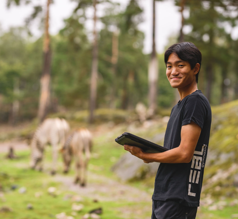 elev med platta och zebror i bakgrunden
