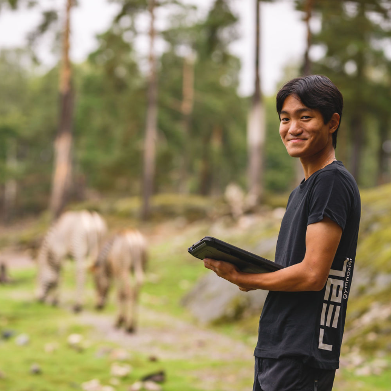 elev med platta och zebror i bakgrunden