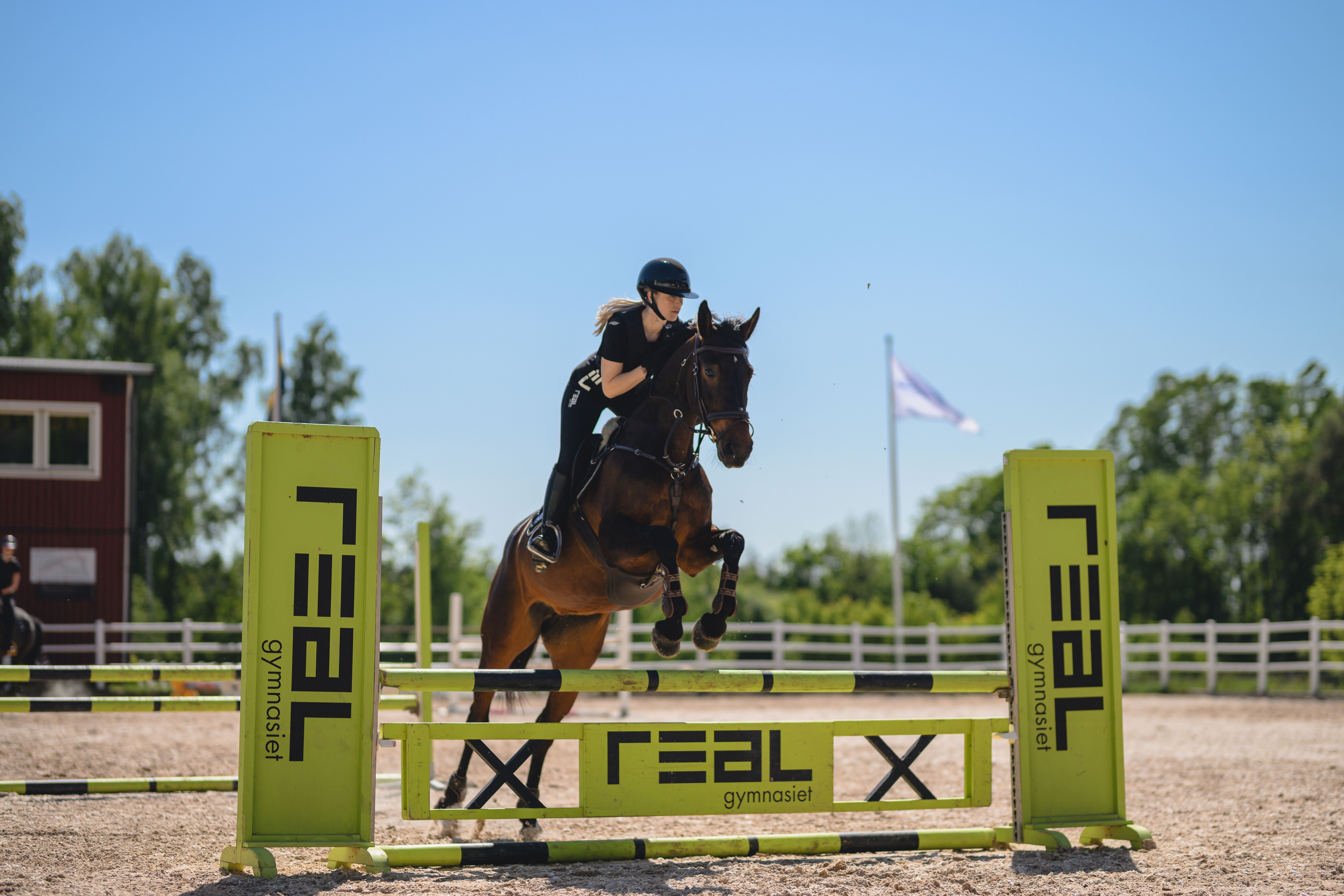 elev och häst på väg över hinder