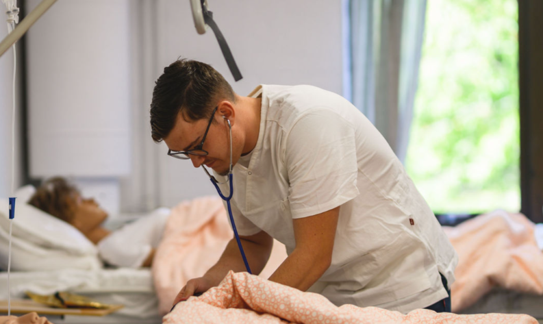 elev med stetoskåp vid en säng