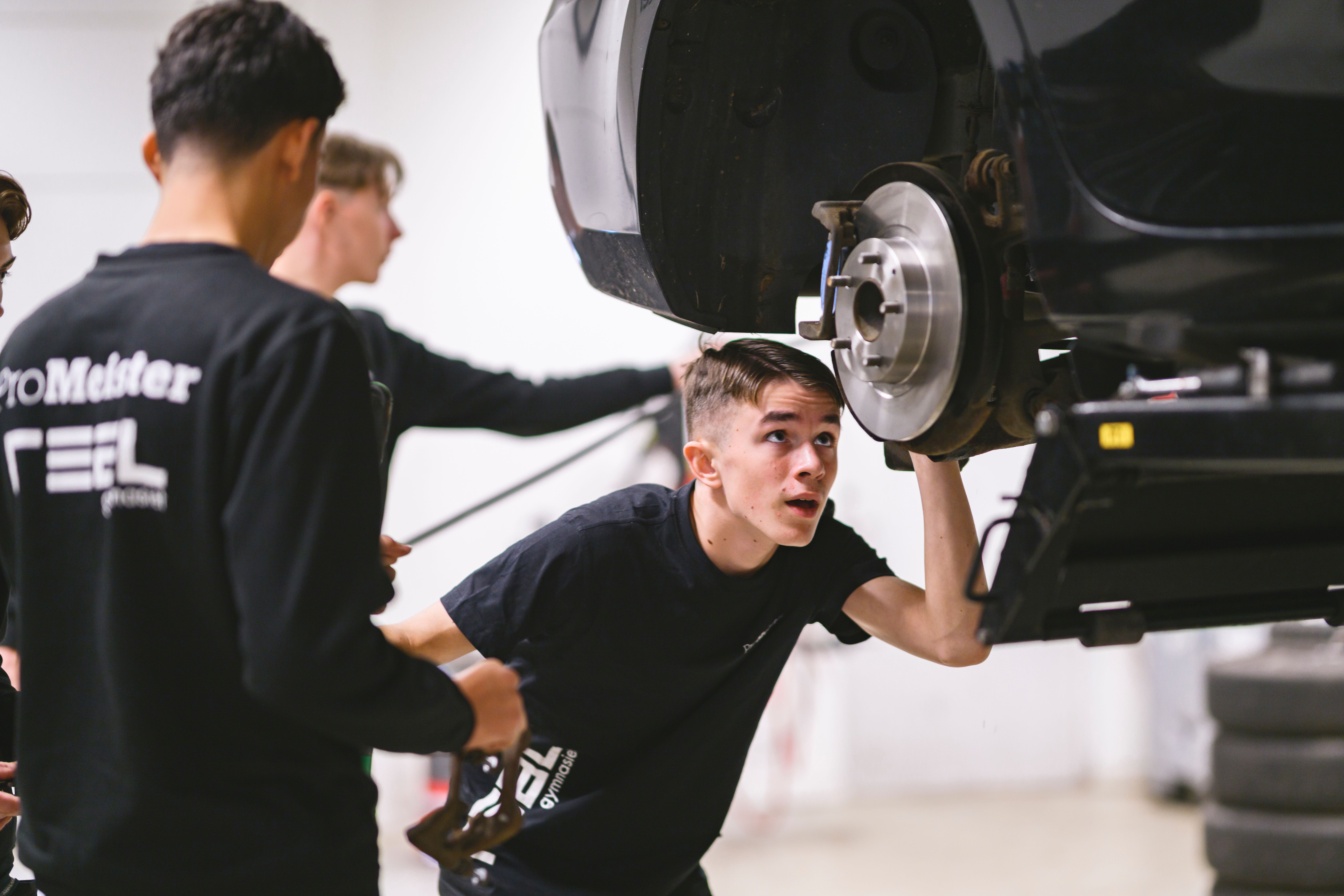Elever mekar med bil i bilverkstad