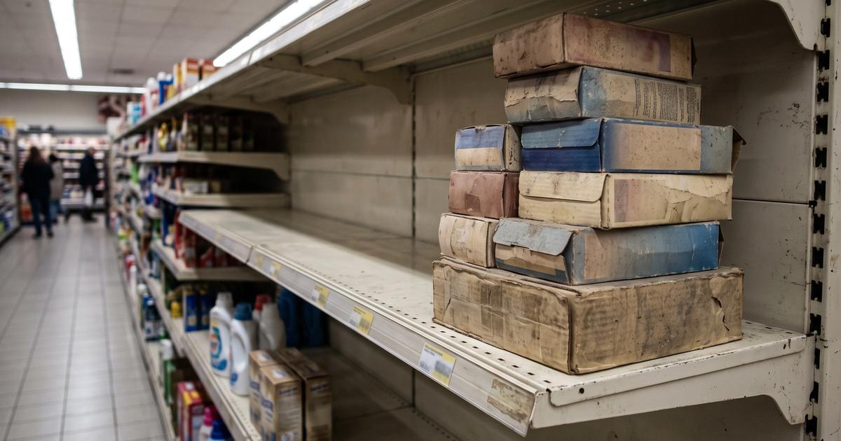 An empty store shelf with a few discontinued product boxes