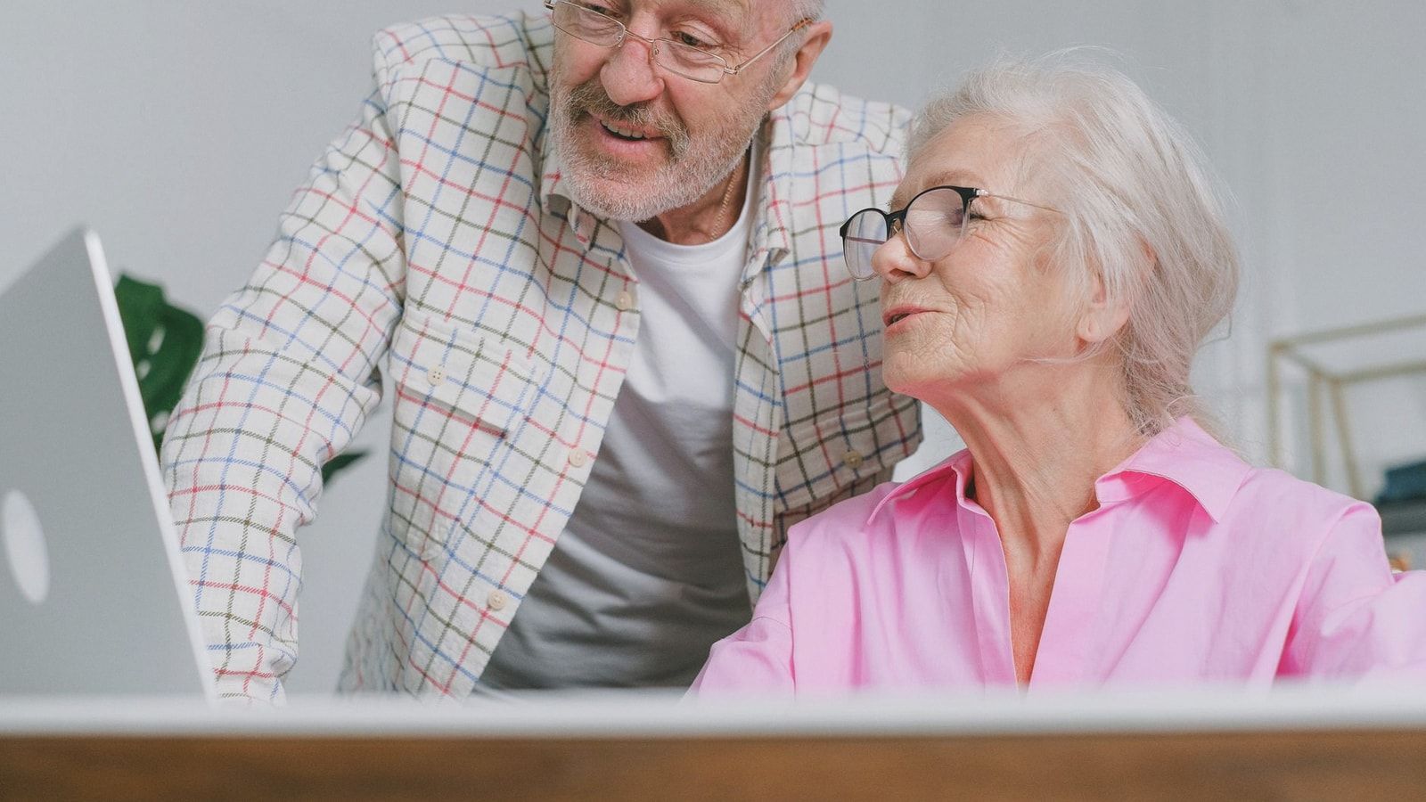 A senior couple enjoying time together while using a laptop, showcasing love and technology.