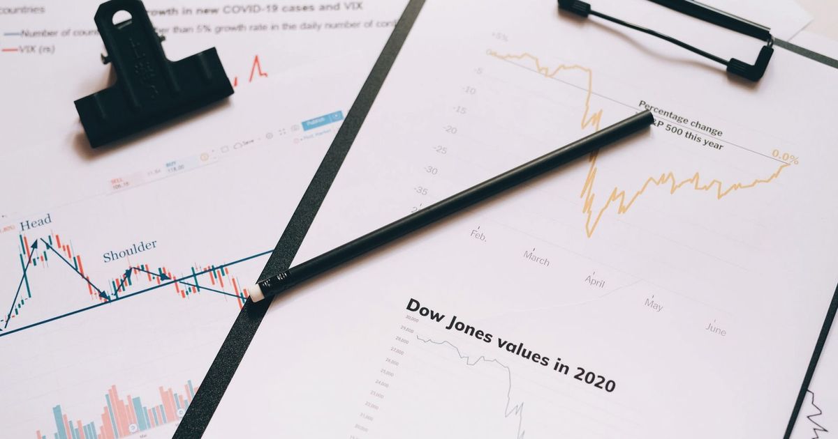 Clipboard with stock market charts and graphs representing financial data analysis.