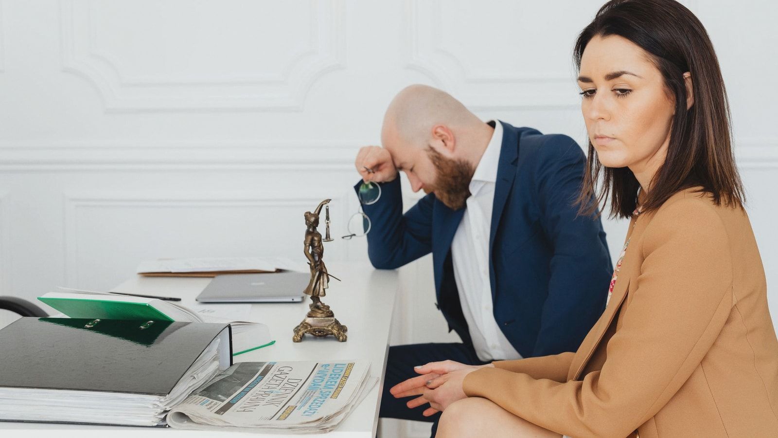 A couple consulting with their lawyer in an office setting, discussing divorce.