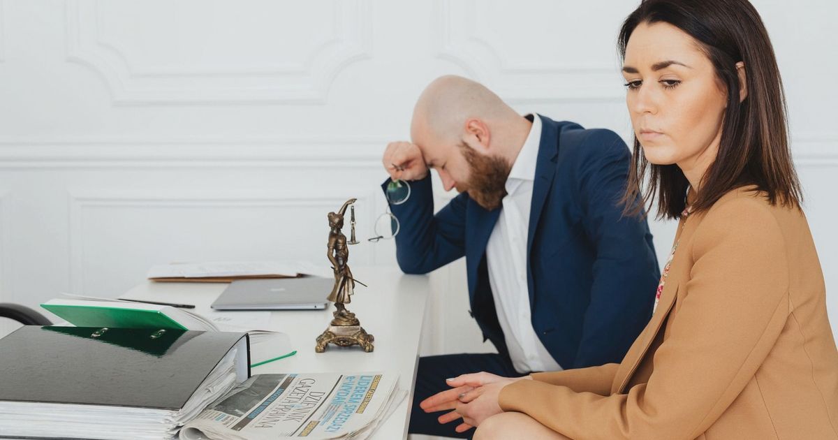 A couple consulting with their lawyer in an office setting, discussing divorce.