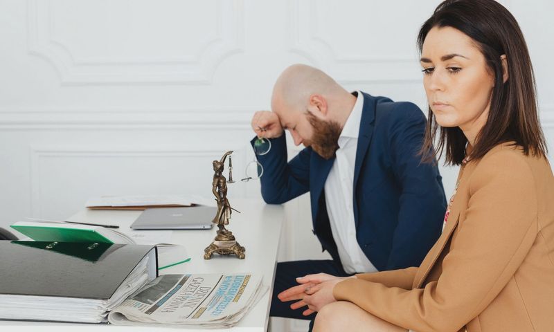 A couple consulting with their lawyer in an office setting, discussing divorce.