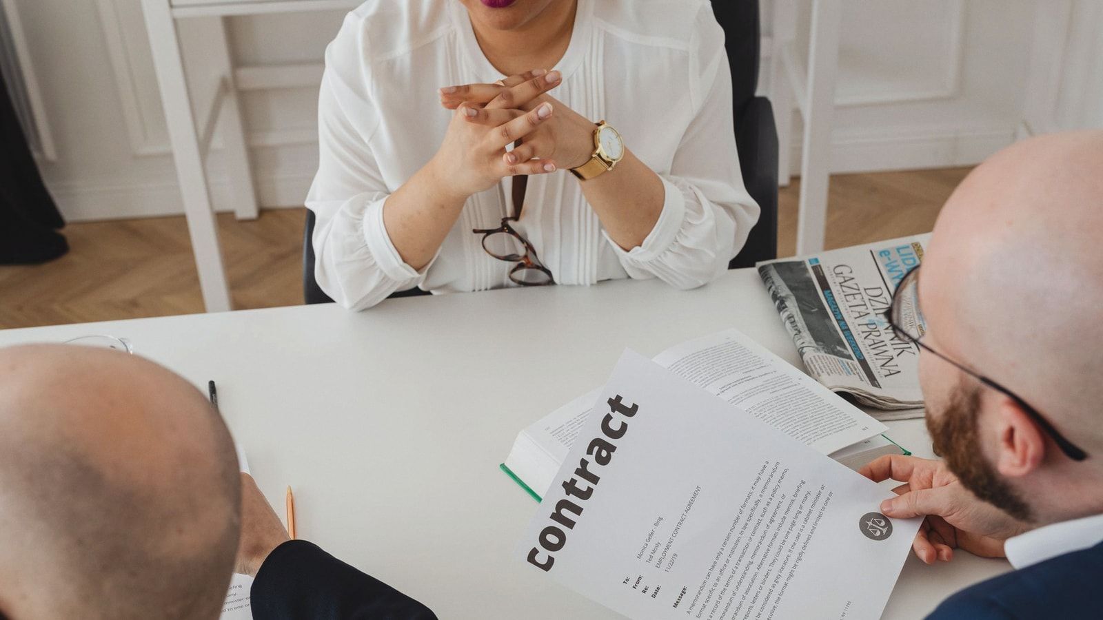 Business professionals discussing a contract in a modern office setting.