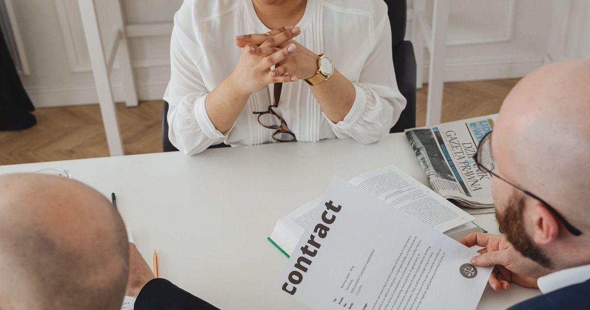 Business professionals discussing a contract in a modern office setting.