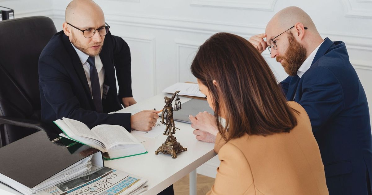 Lawyer consulting clients in a modern office setting, serious discussion.