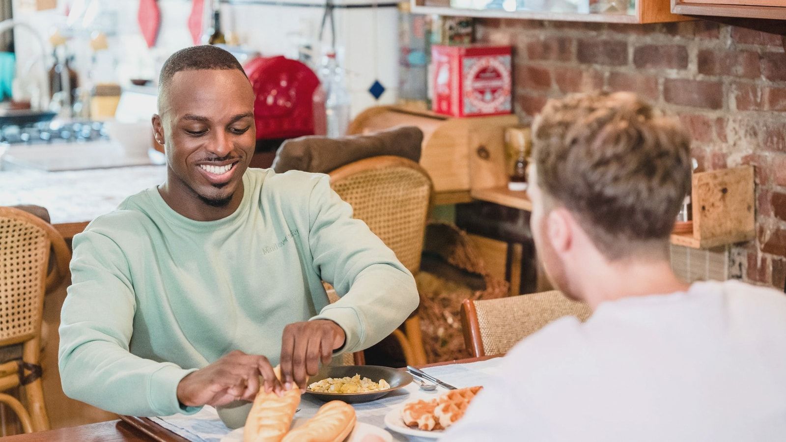 Cheerful couple sharing a meal in the kitchen, embracing a cozy morning ambiance.