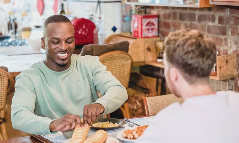 Cheerful couple sharing a meal in the kitchen, embracing a cozy morning ambiance.