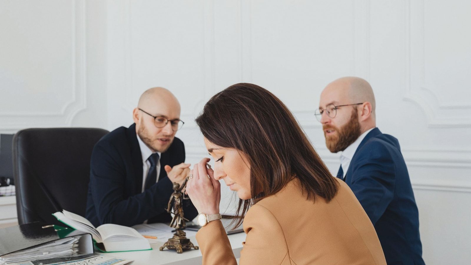A tense discussion among lawyers and a client in an office setting.