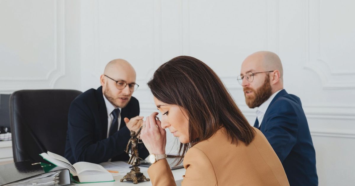 A tense discussion among lawyers and a client in an office setting.