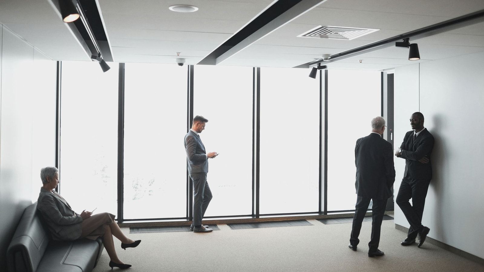 Diverse business professionals interacting in a bright, modern office setting.
