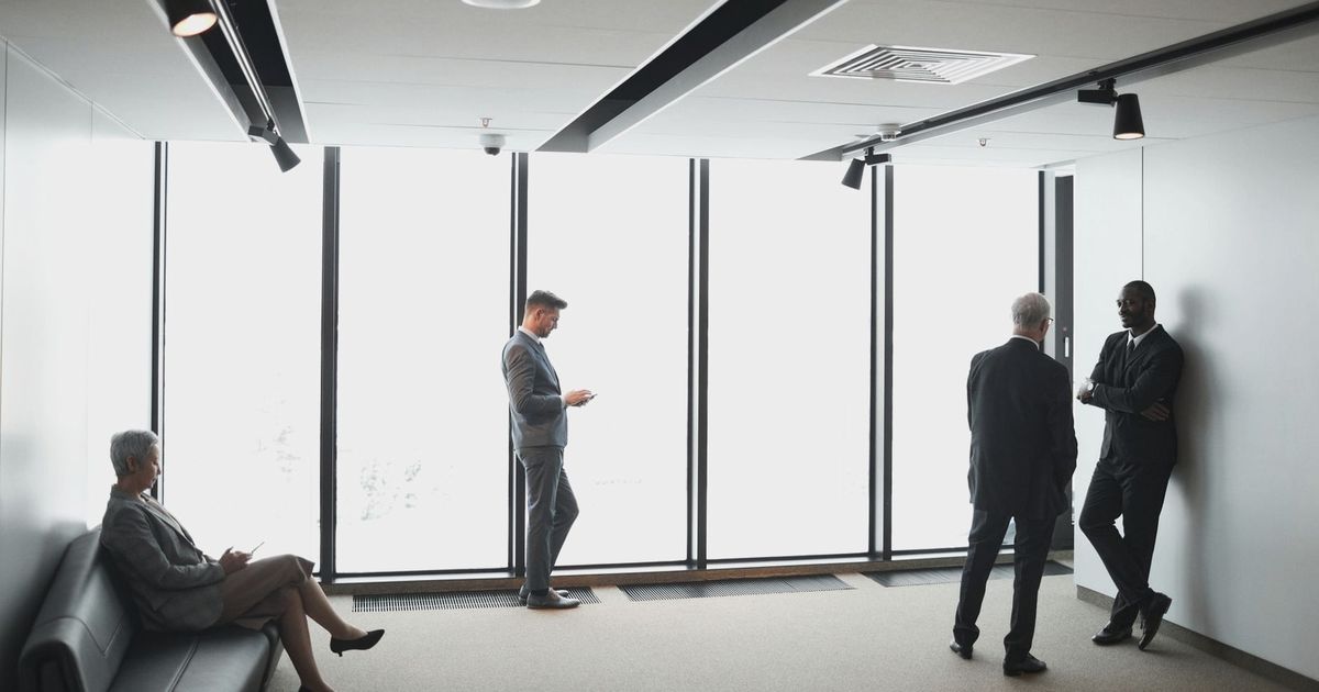 Diverse business professionals interacting in a bright, modern office setting.