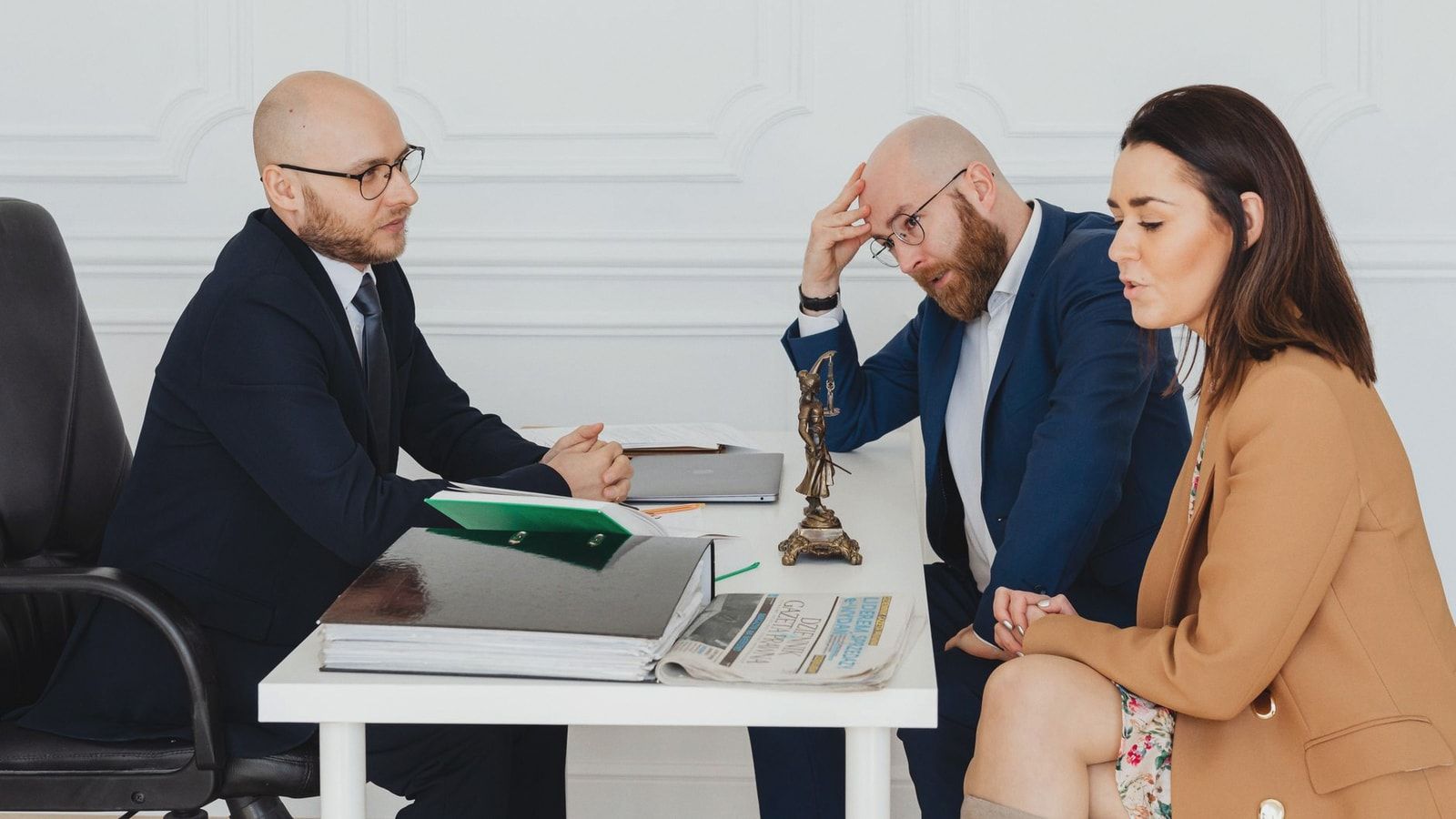 Lawyer consulting couple on divorce settlement in an office setting.