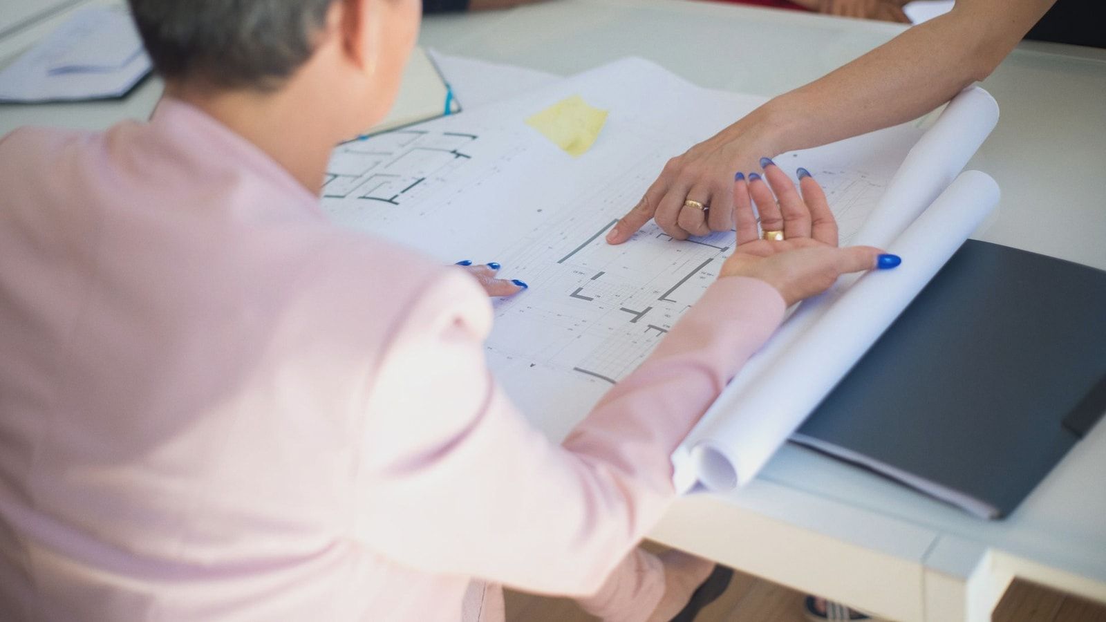 Group discussing architectural floor plans in an office setting.