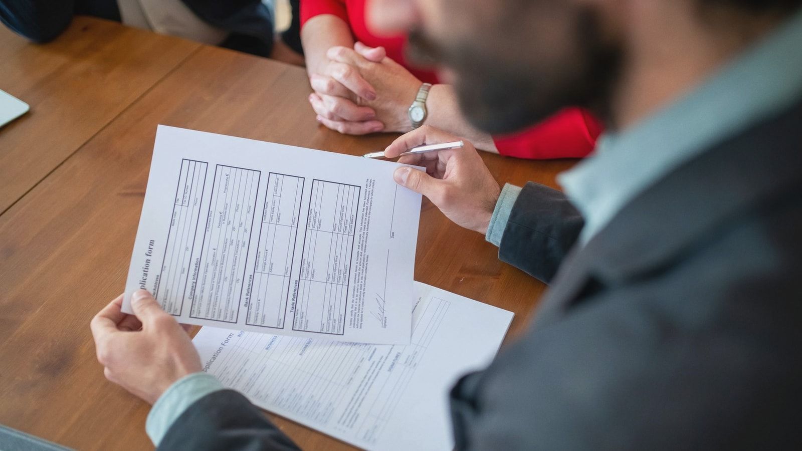 Close-up of businesspeople reviewing documents at a meeting.
