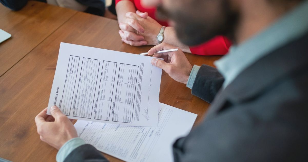 Close-up of businesspeople reviewing documents at a meeting.