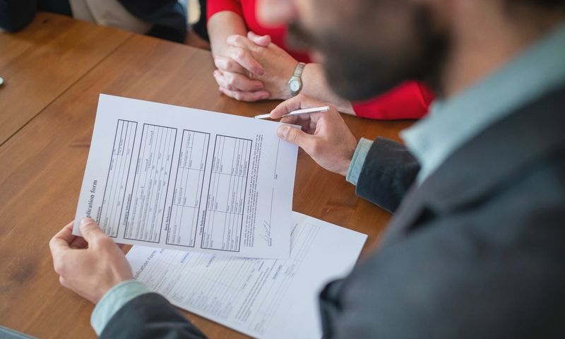 Close-up of businesspeople reviewing documents at a meeting.
