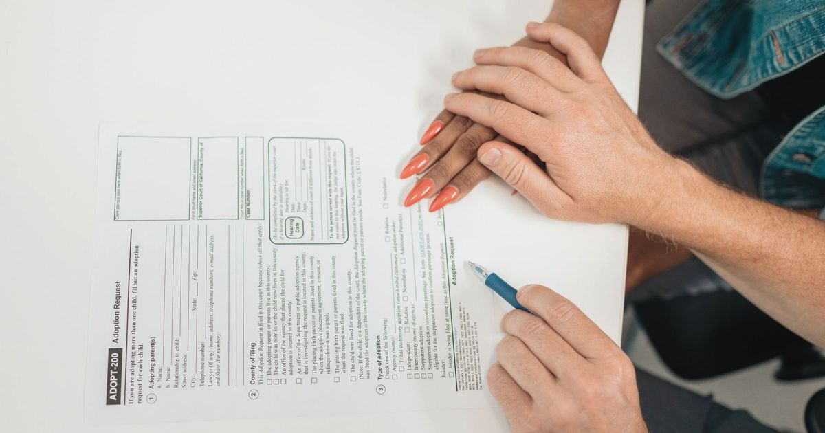 A couple fills out an adoption request form, highlighting commitment and future family planning.