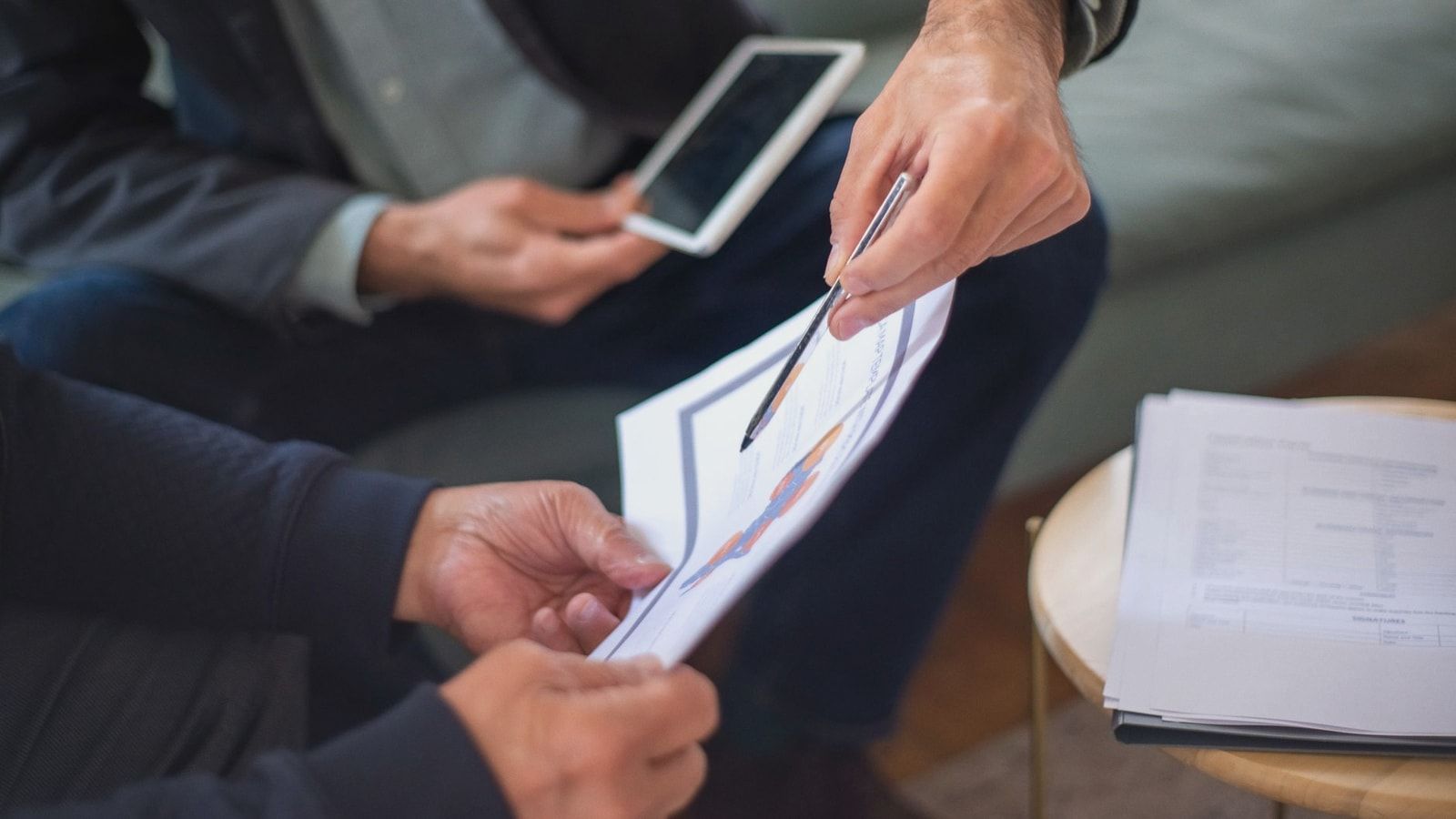 Close-up of two business professionals discussing documents in a meeting.
