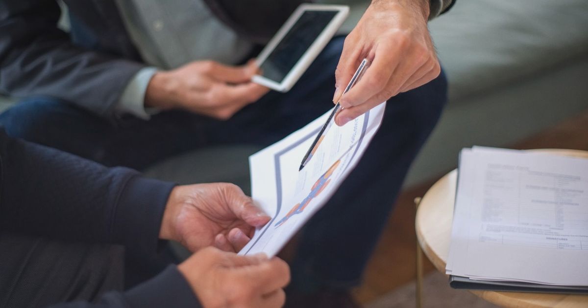 Close-up of two business professionals discussing documents in a meeting.