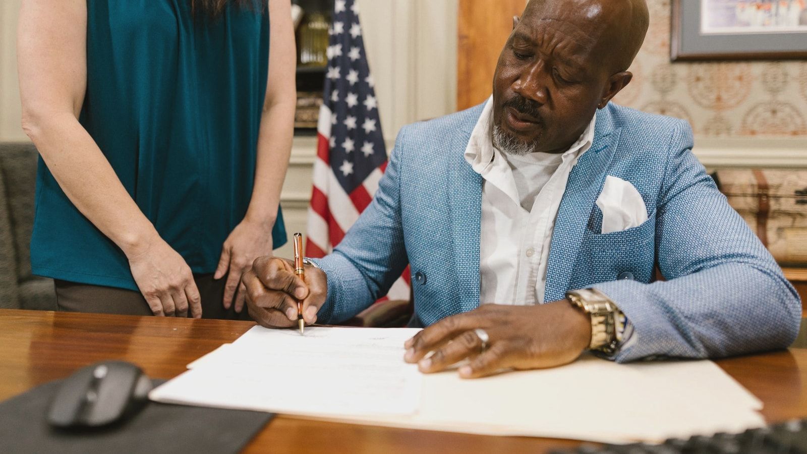 Professional lawyer signing documents in an elegant law office setting, showcasing a serious work environment.